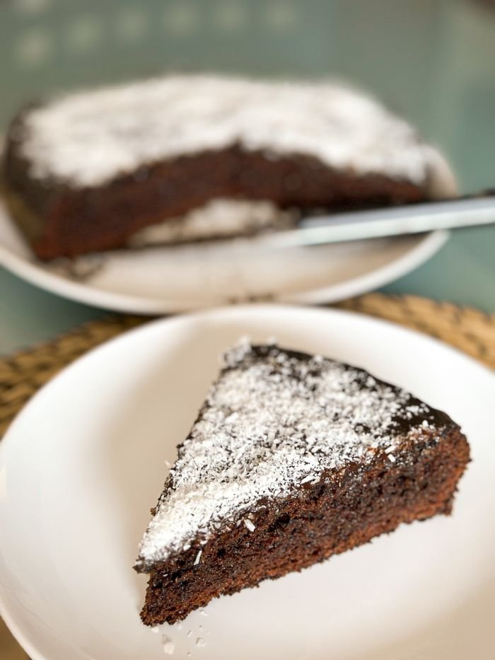 quality-assurance-01 Close-up of a chocolate cake slice topped with powdered sugar, enticing dessert choice.