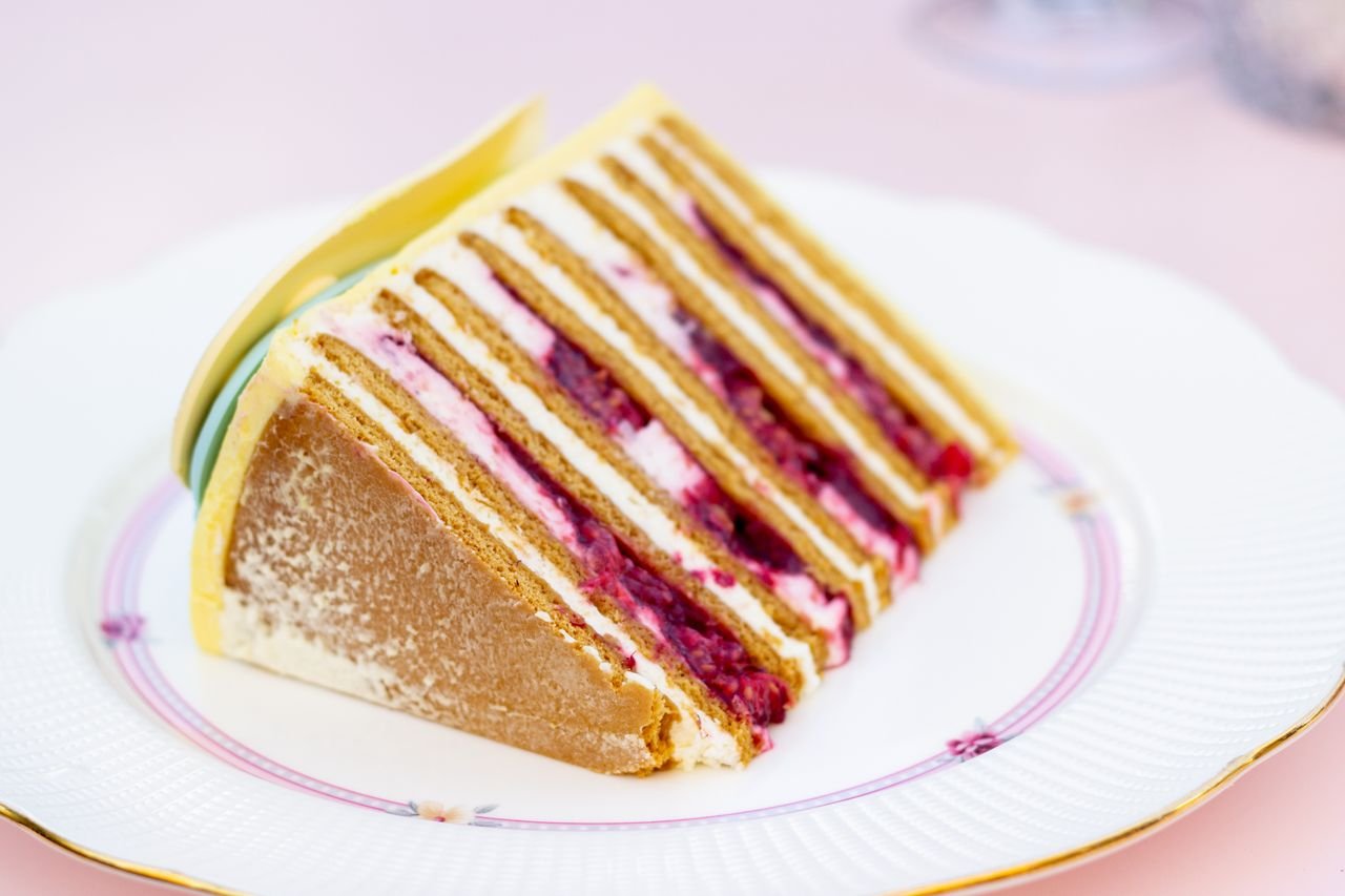 social-feed-img-02 Indulgent slice of layered cake with cream and berries on an elegant plate, perfect for dessert lovers.