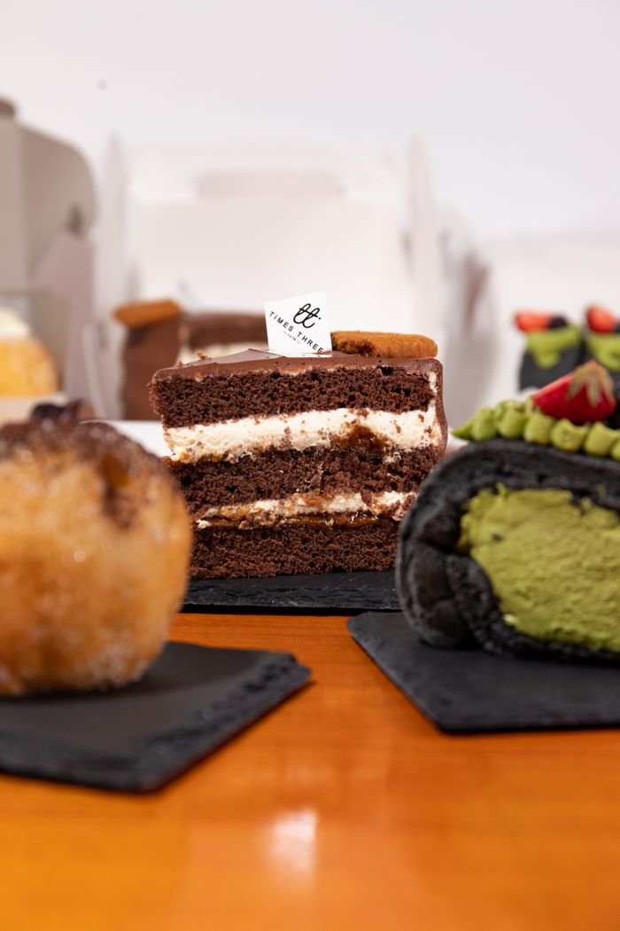 About Indulge in assorted cakes and pastries elegantly arranged on slate boards, promising a sweet culinary delight.
